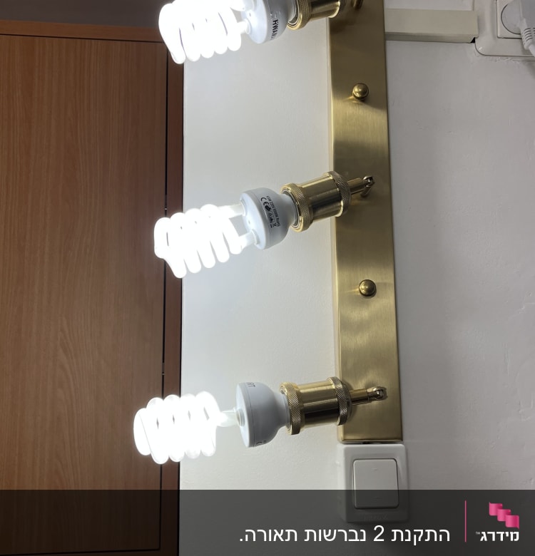 שלוש נורות פלורסנט מחוברות לקיר עם מתג חשמל